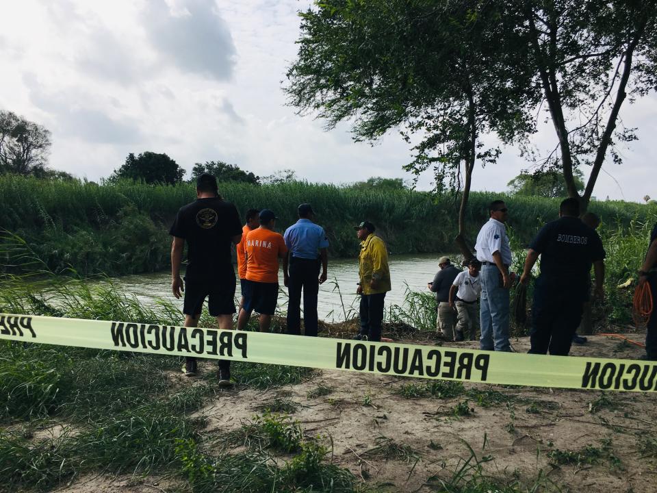 Authorities stand behind yellow warning tape along the Rio Grande bank where the bodies of Salvadoran migrant Oscar Alberto Martínez Ramírez and his nearly 2-year-old daughter Valeria were found, in Matamoros, Mexico, Monday, June 24, 2019, after they drowned trying to cross the river to Brownsville, Texas. Martinez' wife, Tania told Mexican authorities she watched her husband and child disappear in the strong current. (AP Photo/Julia Le Duc)