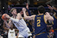 Wake Forest forward Andrew Carr (11) looks to pass the ball as Notre Dame forward Carey Booth, second from left, guard Logan Imes and forward Kebba Njie defend during the first half of an NCAA college basketball game in the second round of the Atlantic Coast Conference tournament, Wednesday, March 13, 2024, in Washington. (AP Photo/Susan Walsh)