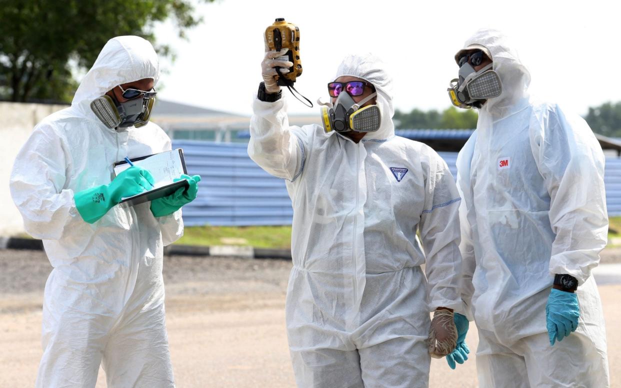 Emergency workers investigate the source of the pollution - AFP