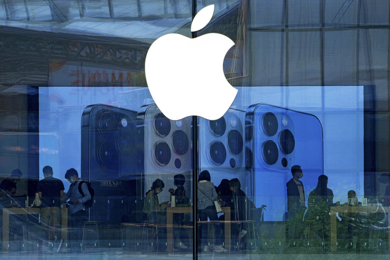 ARCHIVO - En esta fotografía del 28 de septiembre de 2021, la gente prueba los modelos del iPhone en una tienda de Apple en Beijing. (AP Foto/Andy Wong, Archivo)