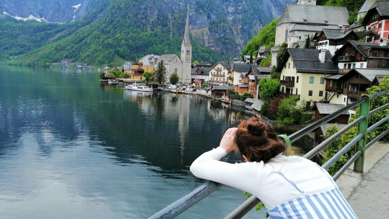 Eine Touristin fotografiert den Hallstätter See in Österreich. Hier scheint die Welt selbst im Corona-Sommer in der üblichen Ordnung zu sein.