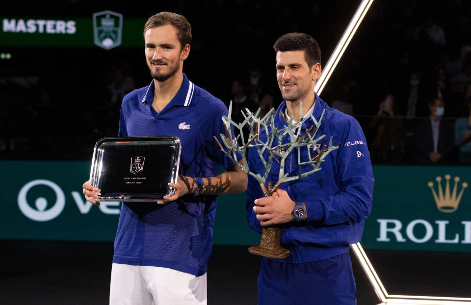 Novak Djokovic (pictured right) and Daniil Medvedev (pictured) pose with their trophies.