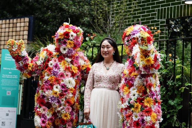 A visitor poses for a photograph in the Balcony Garden