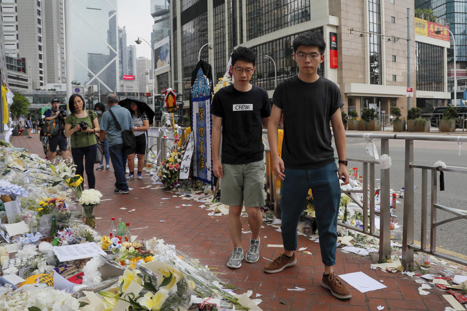 Pro-democracy activist Joshua Wong, right, is accompanied by Nathan Law as they pay respect to a protester who fell to his death after hanging a protest banner against an extradition bill in Hong Kong, Monday, June 17, 2019. Wong, a leading figure in Hong Kong's 2014 Umbrella Movement demonstrations, was released from prison on Monday and vowed to soon join the latest round of protests. (AP Photo/Kin Cheung)