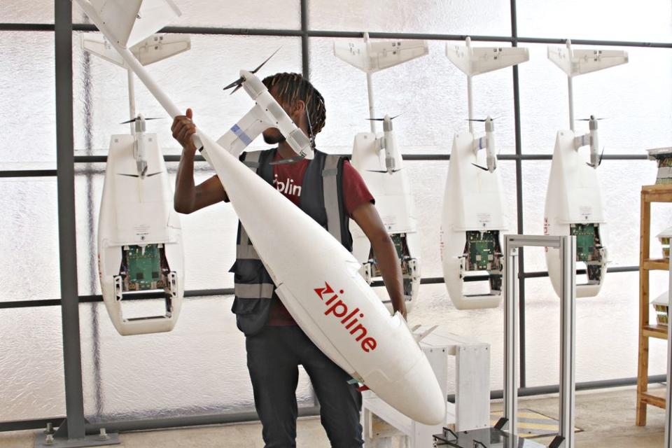 A Zipline employee prepares a delivery drone.