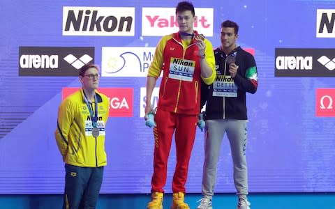 China's Sun Yang, centre, holds up his gold medal as silver medalist Australia's Mack Horton, left, stands away from the podium with bronze medalist Italy's Gabriele Detti right, after the men's 400m freestyle final at the World Swimming Championships in Gwangju, South Korea - Credit: AP