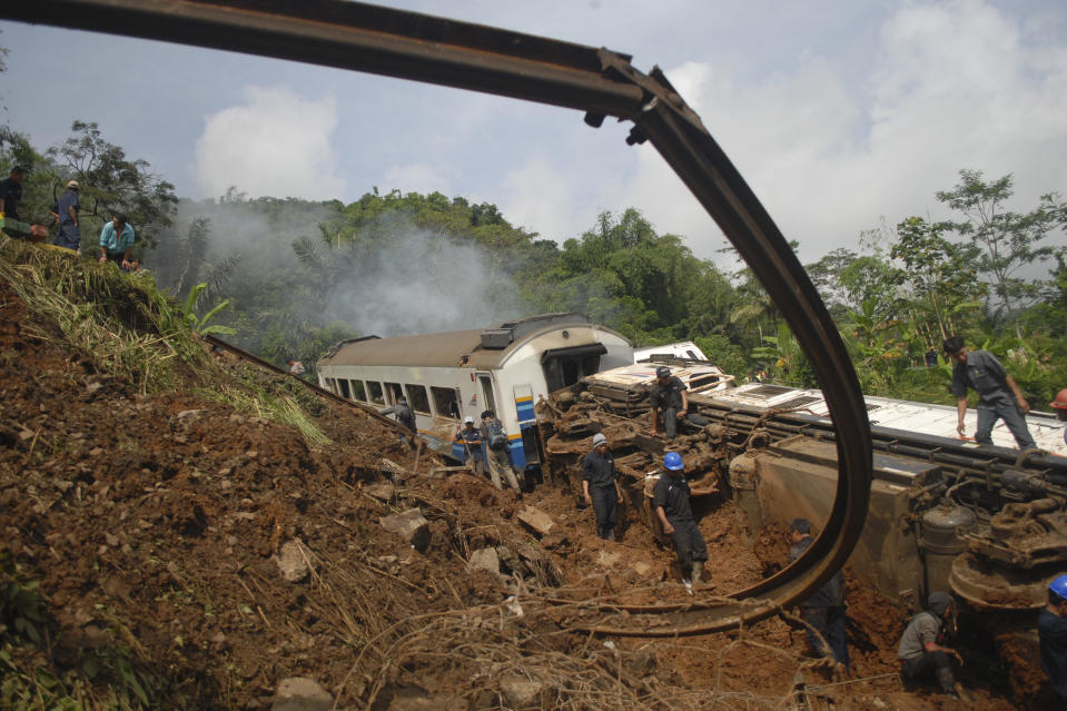 Worker prepare to remove derailed trains in Tasikmalaya, West Java, Indonesia, Saturday, April 5, 2014. A passenger train hit mounds of mud triggered by a landslide and derailed in central Indonesia, killing at least three people and injuring seven, a railway official said Saturday. (AP Photo/Erwin Gobel)