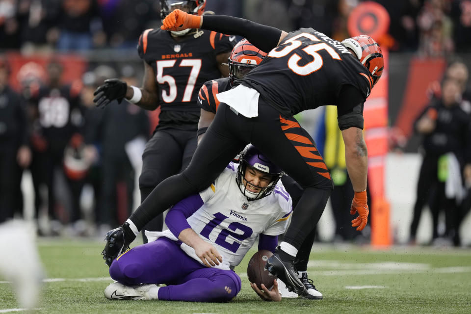 Minnesota Vikings quarterback Nick Mullens (12) slides under Cincinnati Bengals linebacker Logan Wilson (55) during the second half of an NFL football game Saturday, Dec. 16, 2023, in Cincinnati. (AP Photo/Carolyn Kaster)