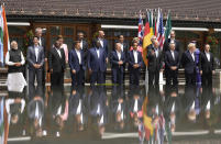 U.S. President Joe Biden, front fourth right, waves as he poses with G7 leaders and Outreach guests for an official group photo at Castle Elmau in Kruen, near Garmisch-Partenkirchen, Germany, on Monday, June 27, 2022. The Group of Seven leading economic powers are meeting in Germany for their annual gathering Sunday through Tuesday. (AP Photo/Markus Schreiber)