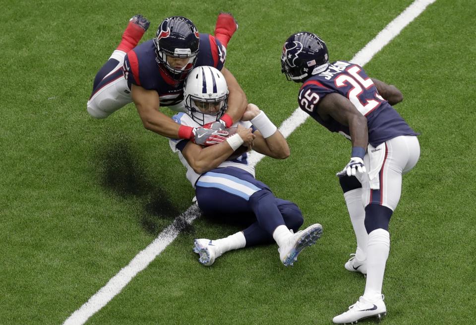 <p>Tennessee Titans quarterback Marcus Mariota, center, is dropped by Houston Texans linebacker Dylan Cole (51) during the first half of an NFL football game, Sunday, Oct. 1, 2017, in Houston. (AP Photo/Eric Gay) </p>