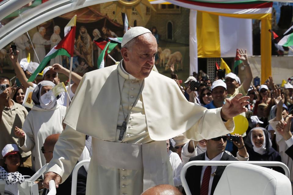 Pope Francis waves to the crowd as he arrives to give Mass at Manger Square