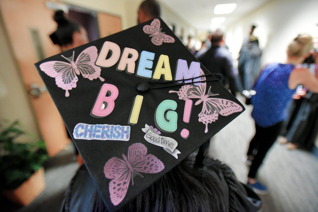 An FSCJ graduate, her mortarboard decorated with inspirational messages, makes her way down the hallway to the school's commencement ceremony in this 2019 photo.