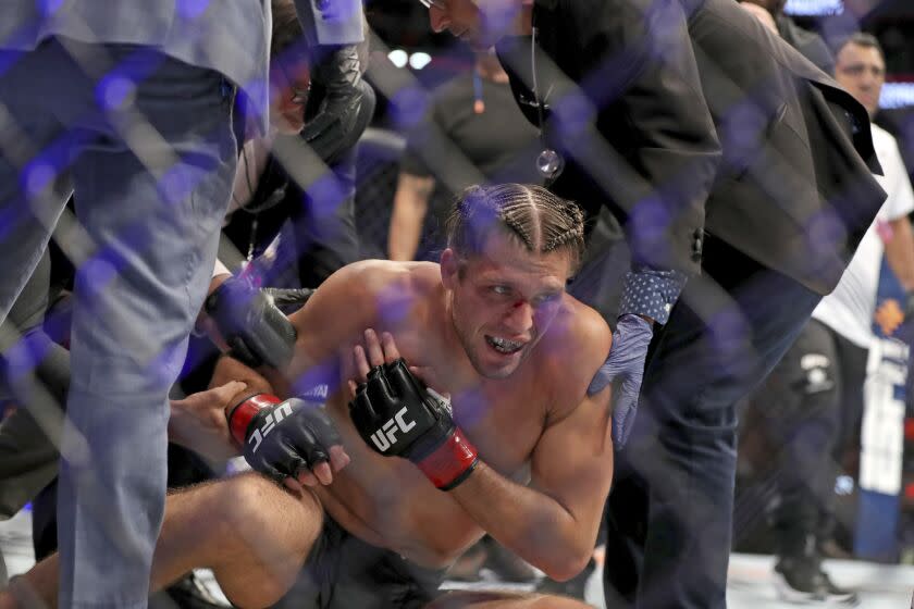 Brian Ortega is seen on the canvas with doctors after suffering a shoulder injury against Yair Rodriguez during their mixed martial arts bout at UFC on ABC 3, Saturday, July 16, 2022, in Elmont, NY. Rodriguez won via first round stoppage after Ortega suffered a shoulder injury. (AP Photo/Gregory Payan)