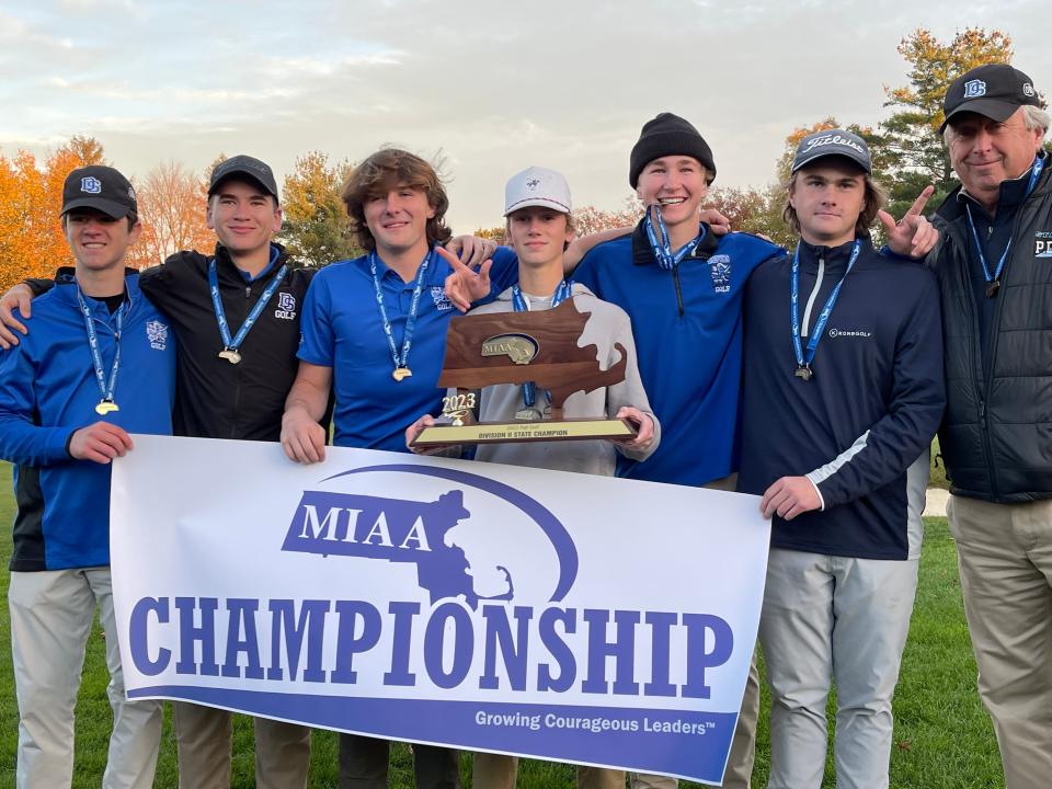 The Dover-Sherborn golf team poses with the Division 2 state championship banner and plaque after winning the title at Thorny Lea in Brockton on Oct. 31, 2023.