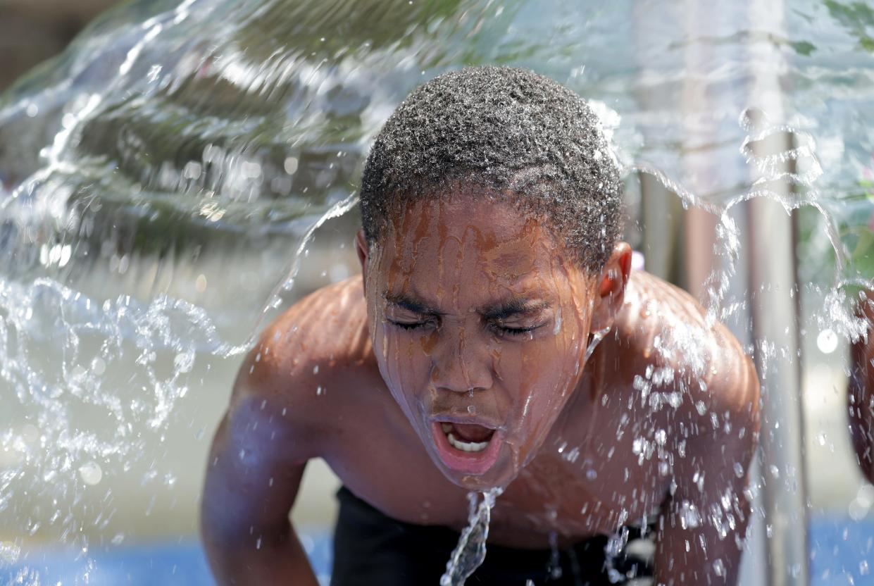 Dionte Williams cools off at the Washington Park splash pad during a heat wave in Milwaukee on  July 6, 2020. Milwaukee County Parks opened several wading pools and splash pads early because of the heat. Dangerous heat waves are becoming more common.