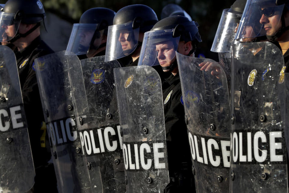 Phoenix Police officers watch protesters rally on June 2, 2020, in Phoenix during demonstrations over the death of George Floyd. The Republican leaders of the Arizona Legislature will not try to defend a new law that has been blocked by a federal judge that limits up-close filming of police, a decision that essentially ends the fight over the contentious proposal. (AP Photo/Matt York, File)