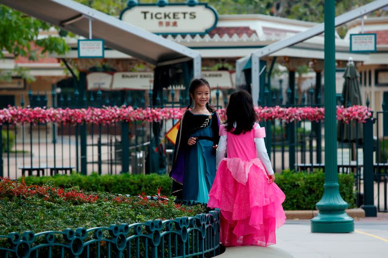 FILE PHOTO: Children play outside the Hong Kong Disneyland theme park after it has been closed, following the coronavirus outbreak in Hong Kong