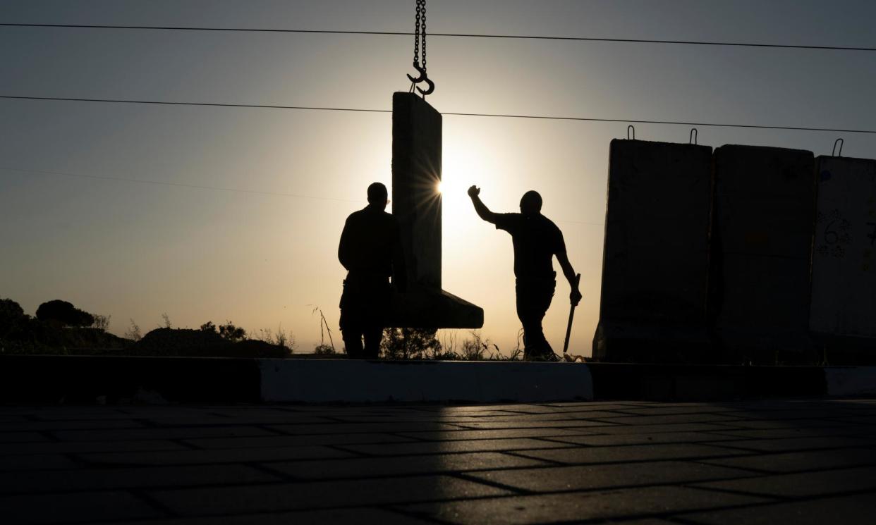 <span>Workers set up a concrete wall in an area in front of a kindergarten in Sderot on 20 March.</span><span>Photograph: Léo Corrêa/AP</span>