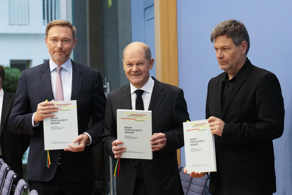 Designated German Chancellor Olaf Scholz, center, designated Finance Minister Christian Lindner, left, and designated Minister for Economics and Climate Protection Robert Habeck, right, present the coalition agreement of their three parties for new German government in Berlin, Germany, Tuesday, Dec. 7, 2021. A coalition of the Social Democratic Party, SPD, the Free Democratic Party, FDP, and the Green party will elect Olaf Scholz as new German Chancellor on Wednesday, Dec. 8, 2021. (AP Photo/Markus Schreiber)