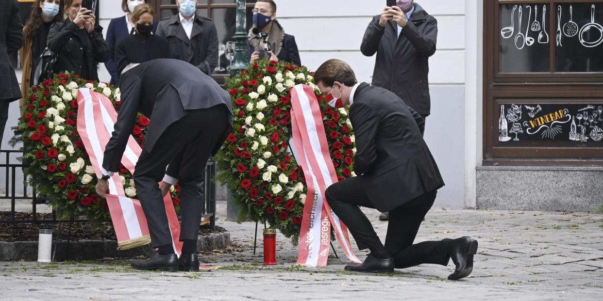 Chancellor Sebastian Kurz (R) kneels down to lay a wreath on November 3, 2020, near the site of a gun attack in Vienna that killed four people.