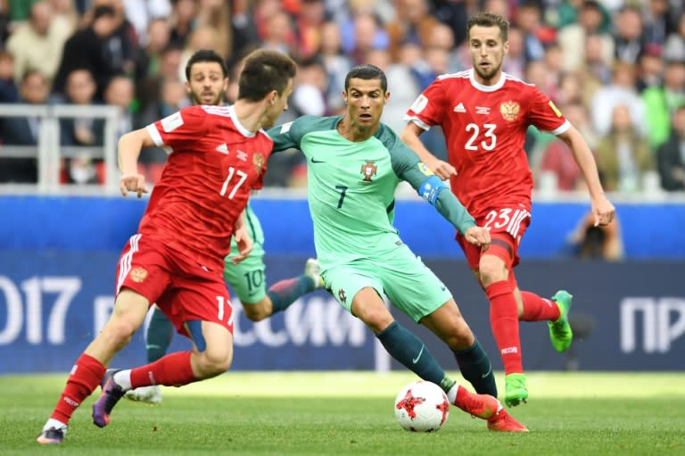 Portugal's forward Cristiano Ronaldo (C) vies with Russia's midfielder Alexander Golovin (L) and Russia's defender Dmitriy Kombarov during the 2017 Confederations Cup group A football match June 21, 2017