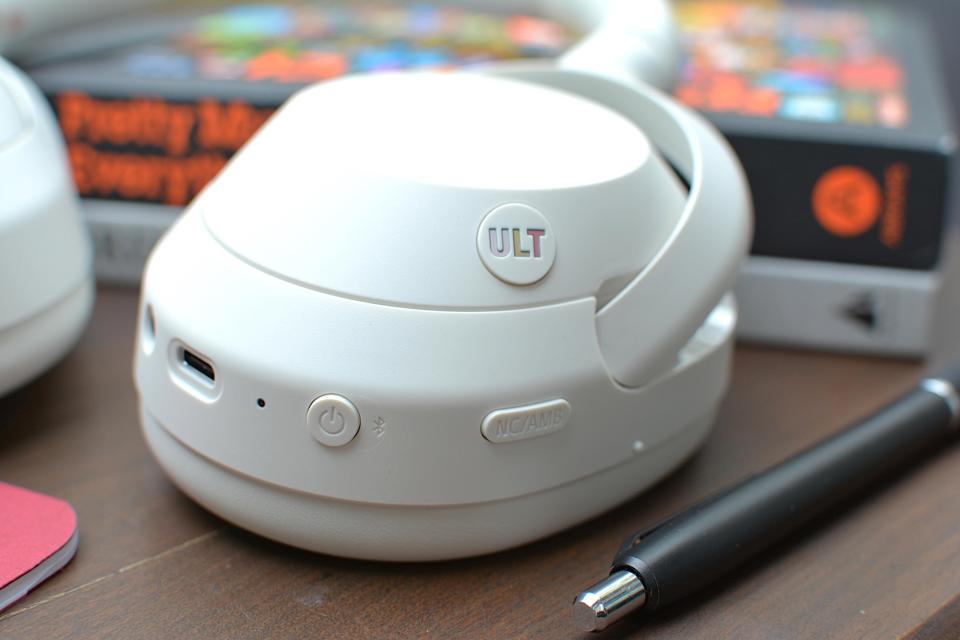 Steuert Details eines Satzes weißer Kopfhörer mit 3,5-mm-Klinkenstecker und USB-C-Anschluss in der Nähe der Netz-, ANC- und ULT-Tasten.