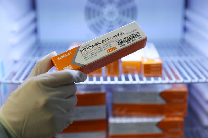 Medical worker takes a box of Sinovac's vaccine against the coronavirus disease (COVID-19) in Qingdao