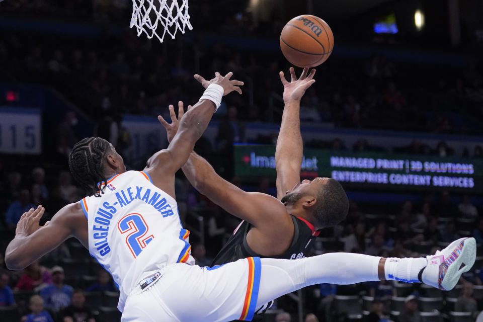 Houston Rockets guard Eric Gordon, right, shoots in front of Oklahoma City Thunder guard Shai Gilgeous-Alexander (2) during the first half of an NBA basketball game Wednesday, Dec. 1, 2021, in Oklahoma City. (AP Photo/Sue Ogrocki)