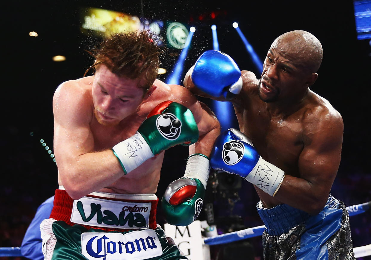 LAS VEGAS, NV - SEPTEMBER 14:  (L-R) Floyd Mayweather Jr. throws a right to Canelo Alvarez during their WBC/WBA 154-pound title fight at the MGM Grand Garden Arena on September 14, 2013 in Las Vegas, Nevada.  (Photo by Al Bello/Getty Images) 