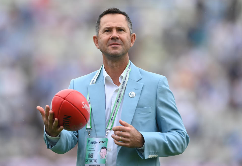 Ricky Ponting plays with an AFL ball during broadcast.