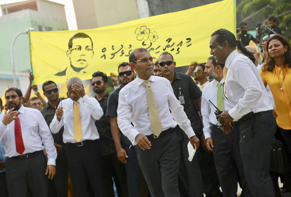 Maldives’ former president Mohamed Nasheed, arrives to address the public in Male, Maldives, Thursday, Nov.1, 2018. Nasheed, the first democratically elected president of the Maldives returned home Thursday after more than two years in exile to escape a long prison term. Banner in Divehi language reads, " This love is from Heart To Heart " (AP Photo/Mohamed Sharuhaan)