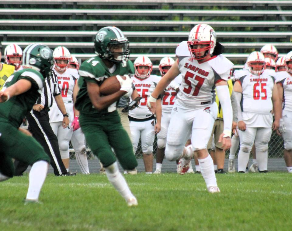 Dover's Amari Lewis, left, runs away from Sanford's Canton Hill during action Friday night at Dunaway Field