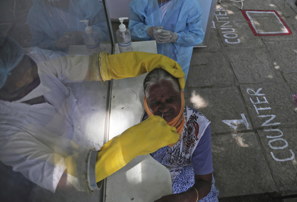 A health worker takes a nasal swab sample at a COVID-19 testing center in Hyderabad, India, Saturday, Oct. 3, 2020. India has crossed 100,000 confirmed COVID-19 deaths on Saturday, putting the country's toll at nearly 10% of the global fatalities and behind only the United States and Brazil. (AP Photo/Mahesh Kumar A.)