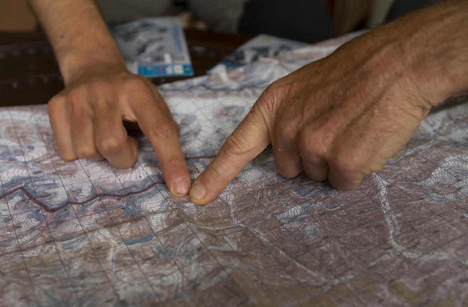 The team leader, Tarcisio Bellò, 57, shows the site of avalanche to his team member in Islamabad, Pakistan, Thursday, June 20, 2019. The renowned Italian mountaineer, who narrowly survived along-with six other members of an expedition on a mountain, burst into tears Thursday when he recalled how helplessly he saw one of his Pakistani colleagues being swept away by an avalanche that struck them at an altitude of around 5,300 meters (17,390 feet) earlier this week. (AP Photo/B.K. Bangash)