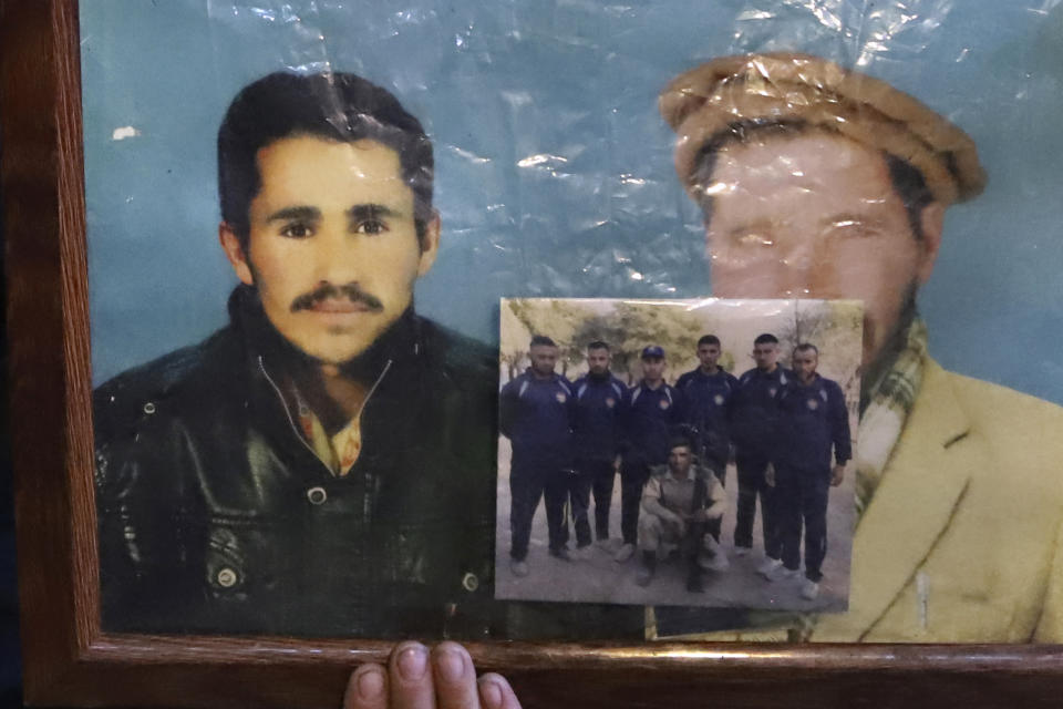 A son of Mohammed Hassan, a Pakistani porter who died on July 27 during a summit of K2, holds a portrait of his father with his grandfather at his home in Tasar, a village in the Shigar district in the Gilgit-Baltistan region of northern Pakistan, Saturday, Aug. 12, 2023. An investigation has been launched into the death of a Hassan near the peak of the world's most treacherous mountain, a Pakistani mountaineer said Saturday, following allegations that dozens of climbers eager to reach the summit had walked past the man after he was gravely injured in a fall. (AP Photo/M.H. Balti)