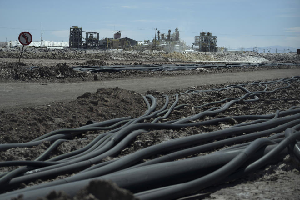 Tubes lie on the grounds of the lithium extraction plant facilities of the SQM Lithium company near Peine, Chile, Thursday, April 18, 2023. At least 1,280 liters of salted groundwater a second – somewhere between 6 to 8 bathtubs – are pumped according to the mine’s numbers. Water converges at rows of blue, green and yellow pools, where lithium-concentrated water is passed from pool-to-pool. (AP Photo/Rodrigo Abd)