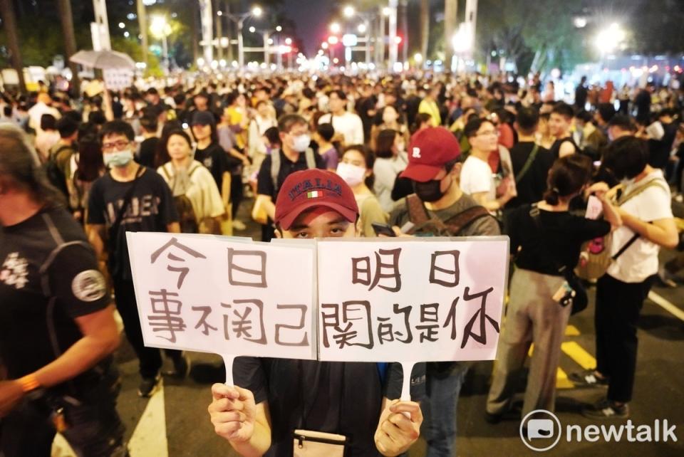 一位民眾在中山南路快車道上高舉「今日事不關己 明日關的是你」手舉拍，提醒民眾國會擴權法案通過的嚴重性。   圖：張良一/攝