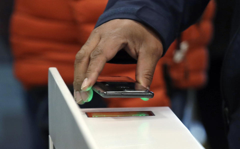 FILE- In this Jan. 22, 2018, file photo a shopper scans an Amazon Go app on a cellphone while entering an Amazon Go store in Seattle. A small number of restaurants and stores are going cash-free in the U.S., looking to cater to customers who increasingly pay with a card or smartphone. But a backlash is growing against the practice that some say discriminates against those who lack back accounts or rely on cash for most of their daily transactions. (AP Photo/Elaine Thompson, File)