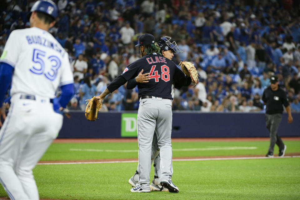 Cleveland Guardians relief pitcher Emmanuel Clase (48) and catcher Bo Naylor celebrate the team's win over the Toronto Blue Jays in a baseball game Friday, Aug. 25, 2023, in Toronto. (Christopher Katsarov/The Canadian Press via AP)