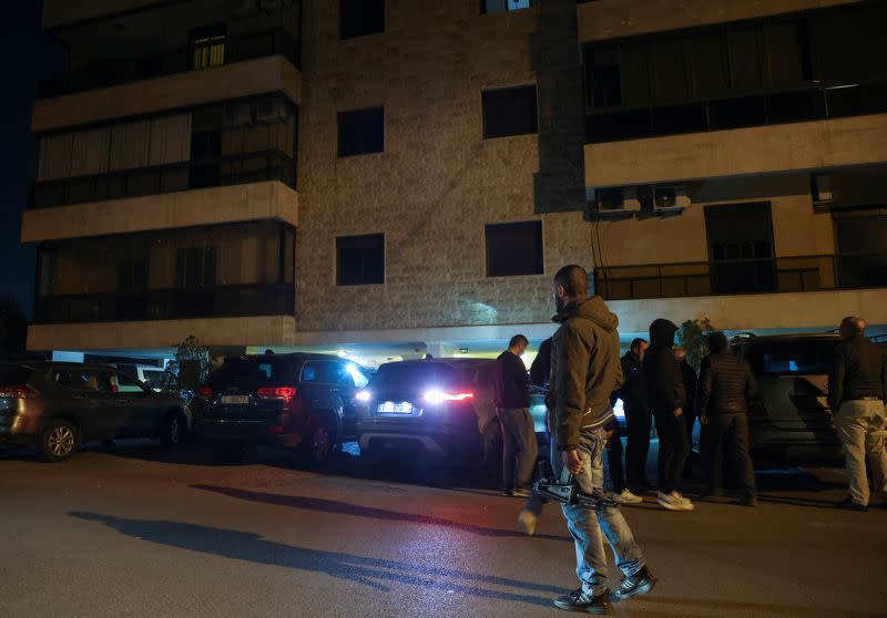 People wait outside the residence of Badri Daher in Hazmieh