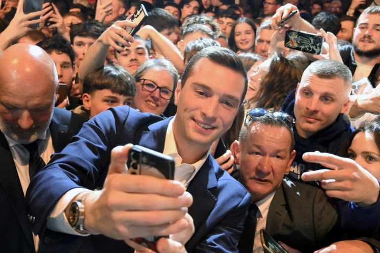 El candidato ultraderechista a las elecciones europeas Jordan Bardella se hace un selfi con simpatizantes durante un mitin, el 22 de marzo de 2024 en Montbeliard, al este de Francia (Patrick Hertzog)