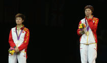 LONDON, ENGLAND - AUGUST 01: Xiaoxia Li of China stands on the podium for her national anthem after winning the Gold medal and Ning Ding of China (L) the Silver following the Women's Singles Table Tennis Gold Medal match on Day 5 of the London 2012 Olympic Games at ExCeL on August 1, 2012 in London, England. (Photo by Feng Li/Getty Images)