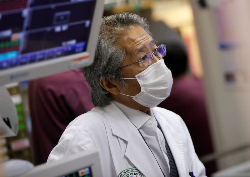 Dr. Yasuhiko Taira listens to staff members to get updates on patients at the ICU for the coronavirus disease (COVID-19) patients at St. Marianna Medical University Hospital in Kawasaki, Japan