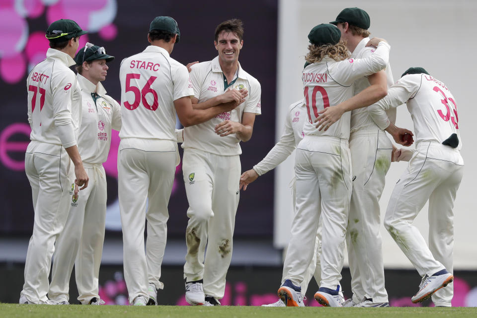 FILE - Australia's Pat Cummins, center, is congratulated by teammates after dismissing India's Shubman Gill for 50 runs during play on day two of the third cricket test between India and Australia at the Sydney Cricket Ground, Sydney, Australia on Jan. 8, 2021. Cummins was named as the new Australian team captain, Friday, Nov. 26, 2021 after the resignation of former captain Tim Paine, Friday, Nov. 19. (AP Photo/Rick Rycroft, File)