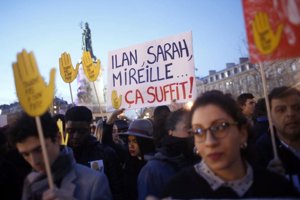 People gather at Republique square to protest against anti-Semitism, in Paris, France, Tuesday, Feb. 19, 2019. The banner refers to French jews assassinated recently with the words reading : It is enough. In Paris and dozens of other French cities, ordinary citizens and officials across the political spectrum geared up Tuesday to march and rally against anti-Semitism, following a series of anti-Semitic acts that shocked the nation. (AP Photo/Thibault Camus)