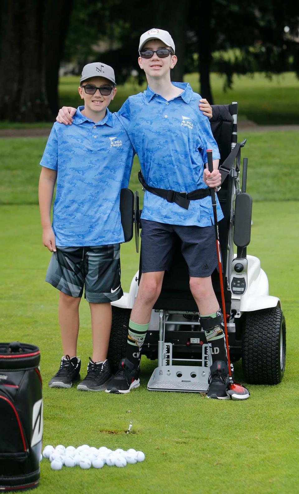 Tony Mercurio, 11, left, and his brother Vinny Mercurio, 13, of North Royalton, at the Firestone Country Club, Wednesday, June 9, 2021 in Akron, Ohio. Vinny uses an Ottobock paramobile device to play golf with Tony on a PGA Junior League team. [Karen Schiely/Beacon Journal]