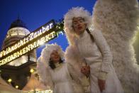 BERLIN, GERMANY - NOVEMBER 26: Hostesses on stilts and dressed as angels walk through the annual Christmas market at Gendarmenmarkt on its opening day on November 26, 2012 in Berlin, Germany. Christmas markets, with their stalls selling mulled wine, Christmas tree decorations and other delights, are an integral part of German Christmas tradition, and many of them opened across Germany today. (Photo by Sean Gallup/Getty Images)