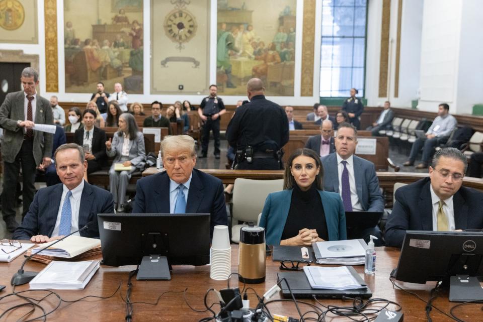 Donald Trump sitting in a courtroom with his lawyers.