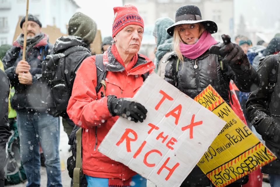 People attend a demonstration against the annual meeting of the World Economic Forum in Davos, Switzerland Sunday, Jan. 15, 2023.