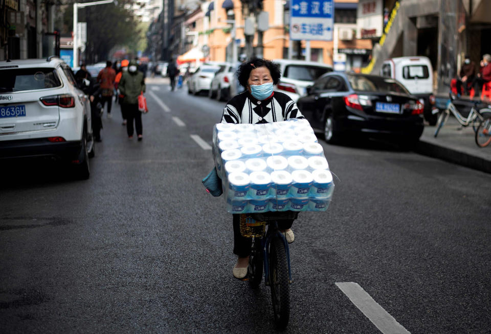 Image: A woman wearing a face mask pedals along a street in Wuhan, in China's central Hubei province (Noel Celis / AFP - Getty Images)
